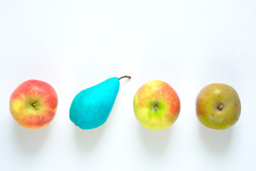 Business metaphor,stand out from the crowd,solution,innovation,idea,consulting, thinking different, row of apples with one  pear blue  colored, flat lay, good copy space