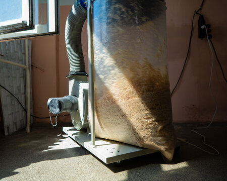 Vacuuming sawdust while sawing wood. Chip blower in furniture production. - Powered by Adobe