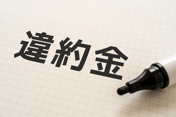 違約金と書かれたノートとマーカー