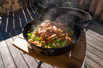 cooking outdoor - sliced and grilled chicken fillet with green salad, corn and carrots