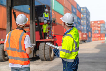 Engineers are overseeing the transportation of cargo with containers inside the warehouse. Container in export and import business and logistics. - obrazy, fototapety, plakaty