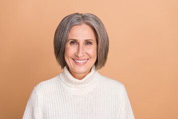 Portrait photo of cheerful positive satisfied mature aged lady white teeth smiling wear warm turtleneck sweater isolated on beige color background