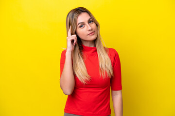 Fototapeta premium Young Uruguayan woman isolated on yellow background thinking an idea