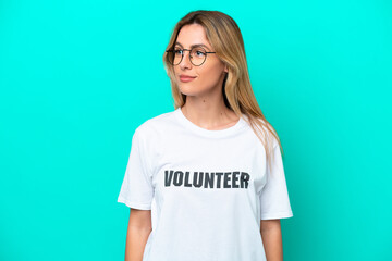 Young volunteer Uruguayan woman isolated on blue background looking side