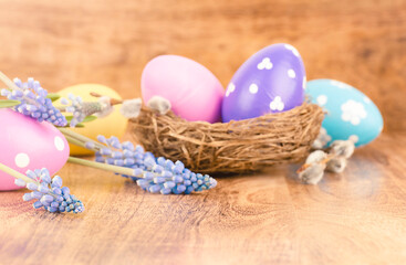 Obraz na płótnie Canvas Defocused Easter eggs and spring flowers on wooden table. Background. Easter concept.