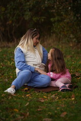 Fototapeta premium The concept of Mother's Day. Mother with little daughter walking in the park in the evening in summer
