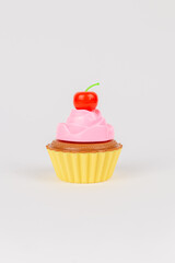 a pink delicious cake with cream cupcake children's plastic toy on a white background