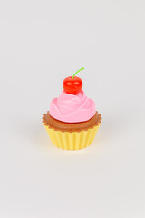 a pink delicious cake with cream cupcake children's plastic toy on a white background