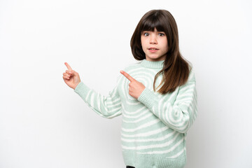 Little caucasian girl isolated on white background frightened and pointing to the side