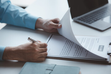 Fototapeta premium A person attends a job interview with a manager to join a company, he holds a resume and interview with information introducing himself and his ability to work. Job application concept.