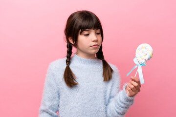 Little caucasian girl holding a lollipop looking to the side