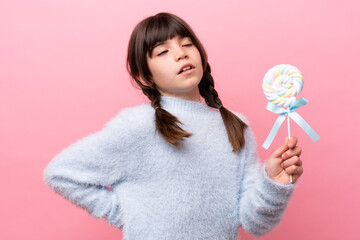 Little caucasian girl holding a lollipop suffering from backache for having made an effort