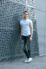 A male fashion model posing on the streets. A young caucasian man wearing casual clothing. Young...