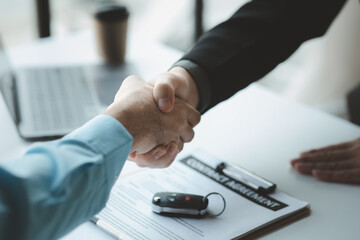 A car salesman is explaining the purchase details and details in the car purchase contract before...