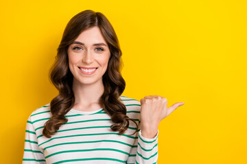 Portrait of confident attractive woman brown wavy hair wear white shirt direct thumb empty space language courses isolated on yellow color background