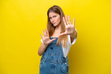 Young caucasian woman isolated on yellow background nervous stretching hands to the front