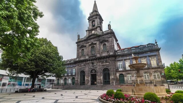 The Trinity Church front view timelapse hyperlapse with cloudy sky and fountain on square in Porto, Portugal. Porto is one of the most popular tourist destinations in Europe.