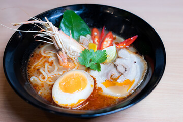 Tom Yum Ramen topped with chashu pork, soy sauce pickled eggs, river prawns and tom yum spices. Tom Yum Ramen is a Japanese-style noodle that fuses with Thai Tom Yum to give it a savory flavor.