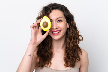 Young caucasian woman isolated on white background holding an avocado while smiling. Close up portrait