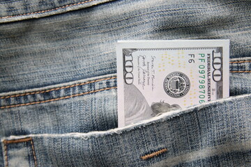 Dollar bills in a back pocket of jeans.
