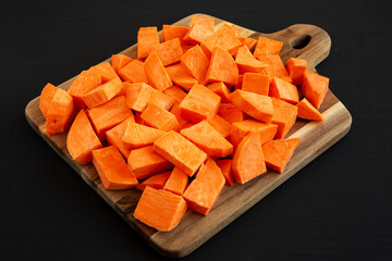 Raw Chopped Sweet Potatoes on a Cutting Board, side view.
