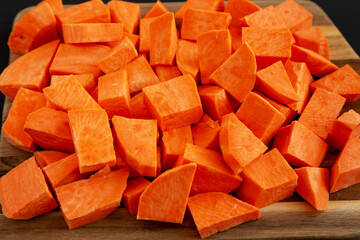 Raw Chopped Sweet Potatoes on a Cutting Board, side view. Close-up.