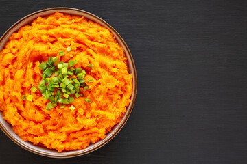 Homemade Creamy Mashed Sweet Potatoes with MIlk and Butter in a Bowl, top view. Copy space.