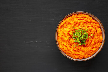 Homemade Creamy Mashed Sweet Potatoes with MIlk and Butter in a Bowl, top view. Space for text.