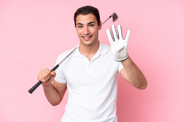 Young golfer player man isolated on pink background happy and counting four with fingers