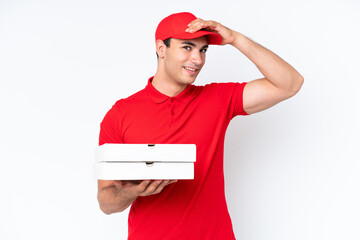 Pizza delivery caucasian man with work uniform picking up pizza boxes isolated on white background doing surprise gesture while looking to the side