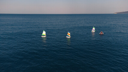 training of children on sailing boats optimist in Mediterranean sea