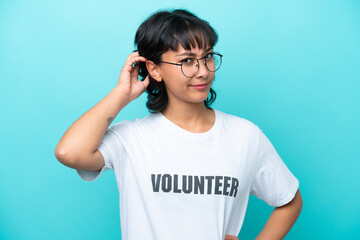 Young volunteer Argentinian woman isolated on blue background having doubts