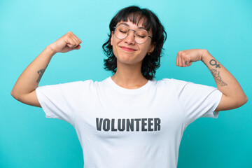 Young volunteer Argentinian woman isolated on blue background doing strong gesture