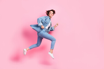 Fototapeta na wymiar Full length photo of adorable cute lady dressed denim jacket jumping high hurrying empty space isolated pink color background
