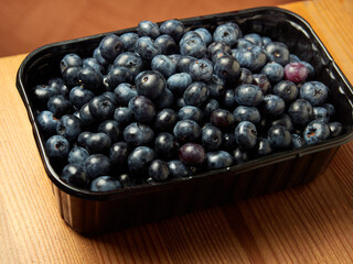 Freshly picked blueberries in a white vintage ceramic bowl. Selective focus, Free text space.