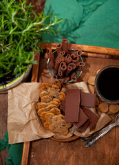Cookies with chocolate chips and cinnamon. Pastries for coffee, food on the table. Flower shaped cookie. Wooden tray