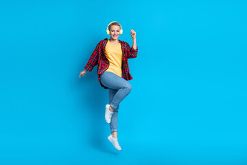 Obraz premium Full size photo of satisfied carefree girl with short hairstyle wear red shirt flying dancing having fun isolated on blue color background
