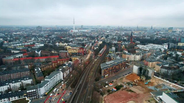 Aerial drone view of Hamburg, Germany. Residential district with buildings, roads with cars, railway, Heinrich Hertz Tower in the distance, cloudy weather