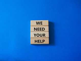 We need your help symbol. Wooden blocks with words We need your help. Beautiful blue background. Business and We need your help concept. Copy space.