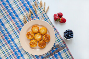 Cottage cheese pancakes, syrniki fritters strawberry, blueberry in yellow plate. Gourmet Breakfast