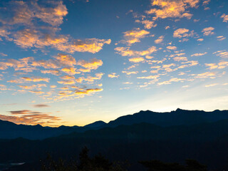 Before sunrise in Alishan, the sky reveals a pinkish glow and the clouds are bathed in orange light.