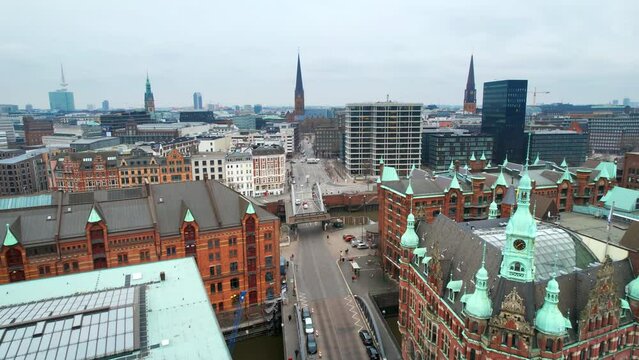Aerial drone view of Speicherstadt in Hamburg, Germany. Residential district with classic buildings, churches, water channels and roads with cars. Cloudy weather