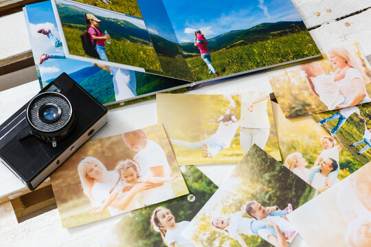 printed photos of family summer vacation lying on desk.