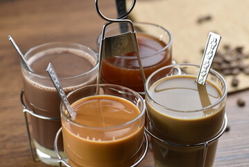 Mix Thai beverage hot drink in glass. Hot milk tea, espresso, cocoa in hand bunch is classic traditional Thai style drink.