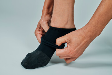 man putting on a compression sock