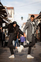 Multiracial couple posing on narrow streets in old part of the sity. Old turkish bazaar in Skopje, North Macedonia. - obrazy, fototapety, plakaty