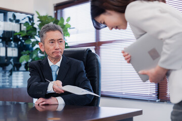 書類を突き返す会社役員の男性