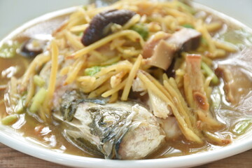 steamed bass fish dressing soybean gravy sauce topping slice ginger and mushroom on plate 