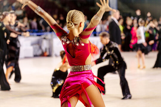 back female dancer in pink dress on background dancing couples