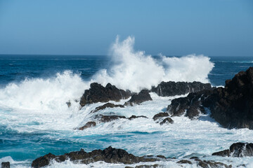 Fototapeta na wymiar ocean waves crashing on rocks, windy weather